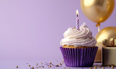 A purple cupcake with white frosting and a lit candle sits on a table, surrounded by balloons for a special celebration