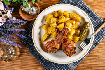 Baked chicken drumsticks with potatoes.