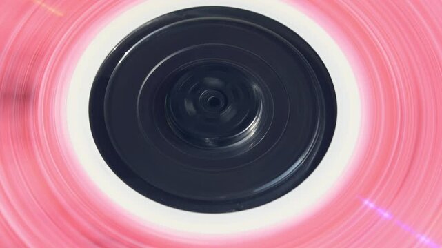 Rapidly spinning pink CD with laser light flash brings back 90s nostalgia and retro aesthetics in crisp 4K video closeup.