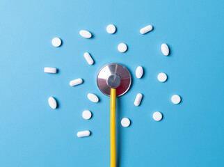 Medical background. Many different various medicine tablets or pills on blue with stethoscope. Healthcare pharmacy and medicine concept