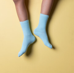 Child wearing socks over blue yellow color background