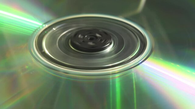Double-sided CD stalls after short spin inside tray as person loads it, capturing fragile charm of 90s tech and imperfect media moments in 4K