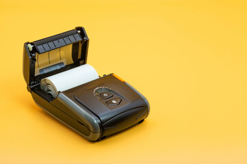 Wireless mobile printer with open cover showing paper roll ready for printing