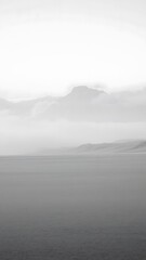 Fototapeta premium Ethereal Monochrome Landscape with Misty Mountain