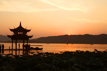 Fototapeta premium Photograph of sunset at Lakeside Pavilion on West Lake in Hangzhou