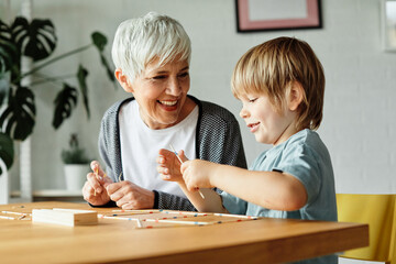 grandchild family child grandparent grandmother game playing boy stick pick up board board game grandson creativity education