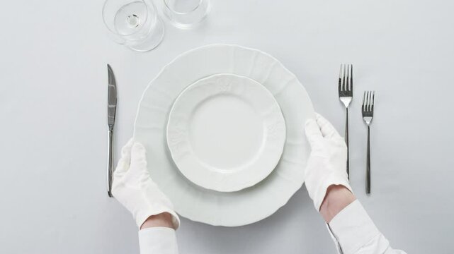 Fancy restaurant, waiter Elegant table setting with white square plate and silverware, arranged for sophisticated dining