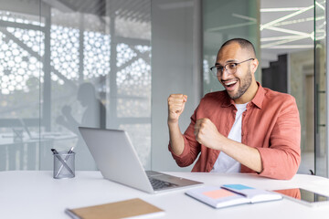 Successful businessman inside office at workplace celebrating victorious achievement results. Man...