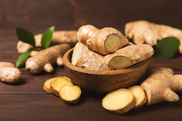 Fresh ginger on wooden background. Dry ginger. Sliced ​​ginger with honey and lemon. Ginger...