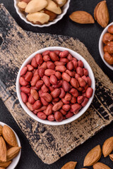 Peanuts or peeled graundnut in a bowl on a dark concrete background