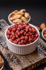 Peanuts or peeled graundnut in a bowl on a dark concrete background