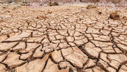** Cracked Earth Texture in Arid Desert Landscape Highlighting Effects of Drought and Climate...