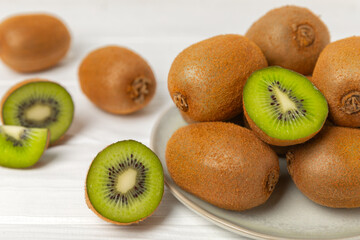 Kiwi on wooden background. Whole fruit and slices pieces of green kiwi on table. fresh ripe juicy kiwi. Tropical fruit. Organic fruit. Healthy eating. Space for text. Copy space
