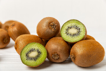 Kiwi on wooden background. Whole fruit and slices pieces of green kiwi on table. fresh ripe juicy...