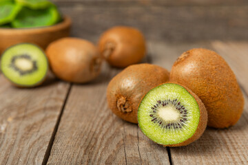 Kiwi on wooden background. Whole fruit and slices pieces of green kiwi on table. fresh ripe juicy...