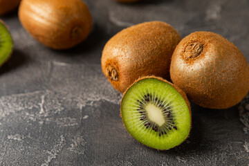 Kiwi on wooden background. Whole fruit and slices pieces of green kiwi on table. fresh ripe juicy...