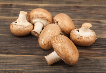 Champignon mushrooms on a wooden background.