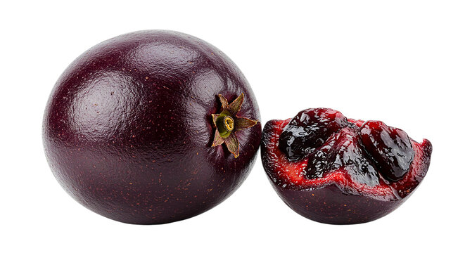 Close up of a whole java plum and a cut java plum on a black background in a studio shot