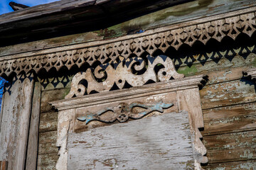 Windows with carved shutters and frames on an old rural house. Beautiful hand-made patterns. 