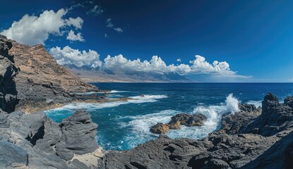 Coastal scenery with waves crashing on volcanic rocks.  Vast ocean expanse under a vibrant sky, dotted with puffy clouds