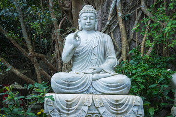 Obraz premium A Serene Buddha Statue Enveloped by Lush, Peaceful Nature and Tranquil Environment Marble Mountains, Vietnam