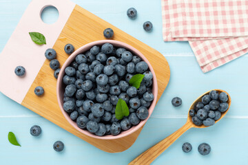 Bowl with fresh bright blueberries on wooden background,top view