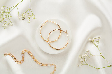Elegant golden jewelry with decoration on textile background, top view