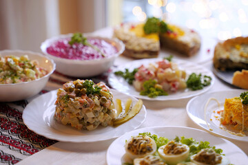 Homemade food on a festive New Year table with focus on mimosa salad.