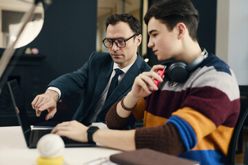 Businessman training online work on laptop to new employee in office
