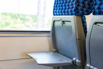 Interior of a modern train or bus with rows of blue seats, and table. Public transportation concept. © Irina Mikhailichenko