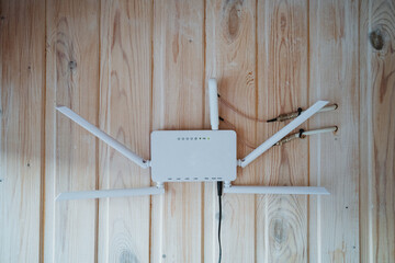 A sleek white router is prominently placed on a wooden wall, showcasing its modern design and...