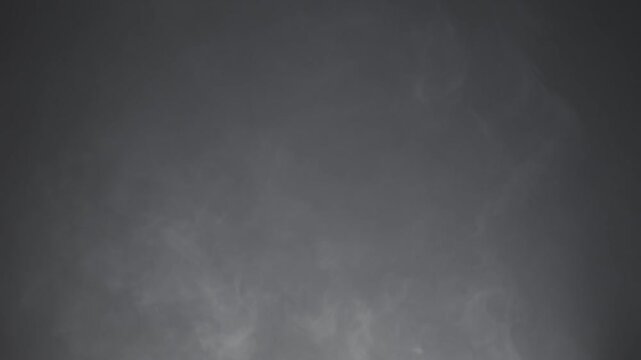 Abstract white smoke in slow motion. Smoke, Cloud of cold fog in light spot background. Light, white, fog, cloud, black background, 4k, ice smoke cloud. Floating fog.