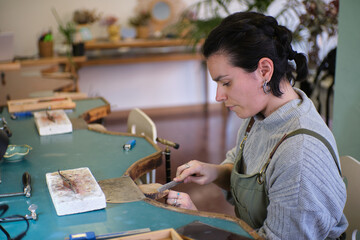 Jeweler working on a jewel in her workshop