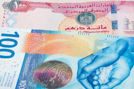 100 United Arab Emirates dirham and 100 Swiss frank banknotes. International trade concept