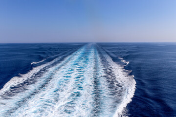 The ocean is calm and blue with a white streak in the middle
