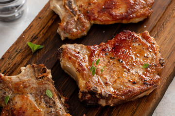 Pork chops grilled or seared on a wooden board