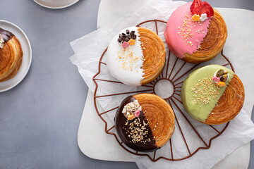 Trendy round croissants dipped in glaze with different fillings