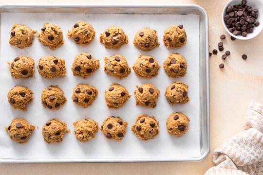 Chocolate chip cookies with pecan nuts, cookie dough ready on a baking sheet