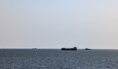 Obraz premium Panorama Silhouette photo of ocean liners or vessels in the ocean, The Cargo ship or Freight ship fleet on service.