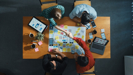 Fototapeta premium Professional developer team sharing idea of Ux Ui design by using mind map. Top down view of group of business people working together to brainstorm or plan mobile phone interface app. Convocation.