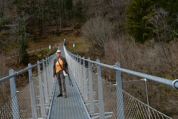 Eine Frau auf e8ner H&auml;ngebr&uuml;cke beim Tennosee im Trentino