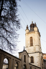 Historic European church tower with adjacent street and vibrant passerby activity in Lviv, Ukraine.