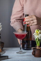 Woman bartender preparing red cocktail with sparkling wine