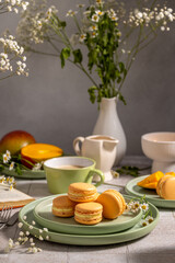 Mango macarons with coffee and flowers creating cozy atmosphere