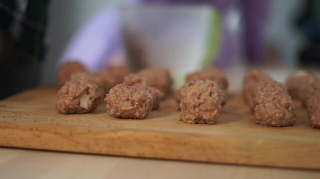 woman mother is cooking making swedish meatballs at home with daughter together talking family time