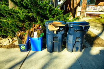 Recycling bins at the curb on a residential street waiting for municipal pick up on a bright sunny spring morning shot in the Toronto  Beaches neighbourhood  in April 