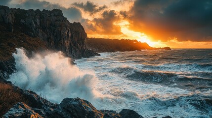 Fototapeta premium Dramatic sunset over stormy ocean waves crashing against rocky cliffs (1)