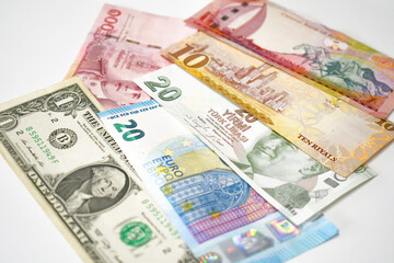 One dollar, 20 euro, 20 Turkish lira, 10 euro, 100 Thai baht and 1 Bahraini dinar banknotes on the table.