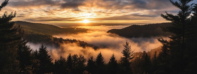 Fototapeta premium Golden Sunrise Through Misty Mountains suitable for nature magazine