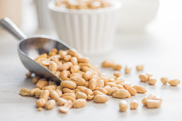 Roasted salted peanuts in scoop on kitchen table